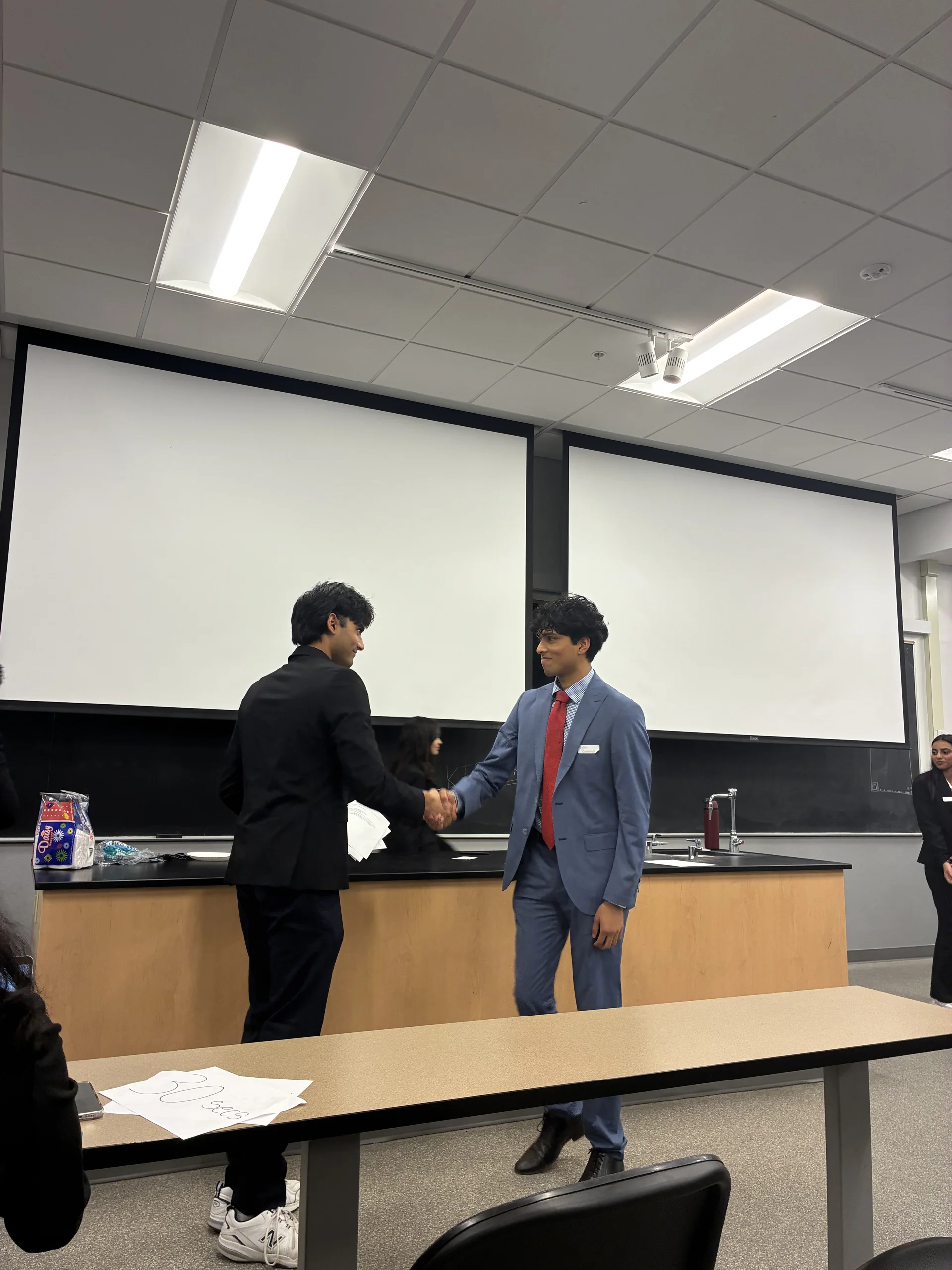 Two KTP members shaking hands after a professional event